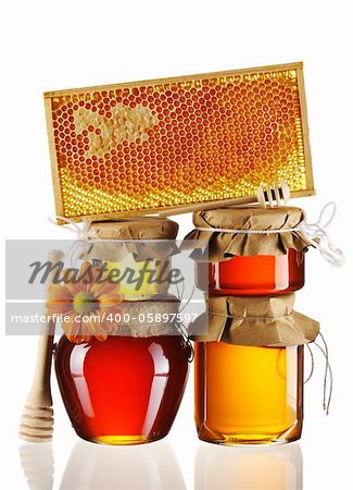 Jars of honey and dipper isolated over white