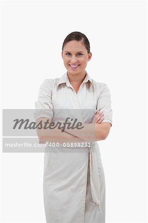 Portrait of a smiling businesswoman posing with the arms crossed against a white background