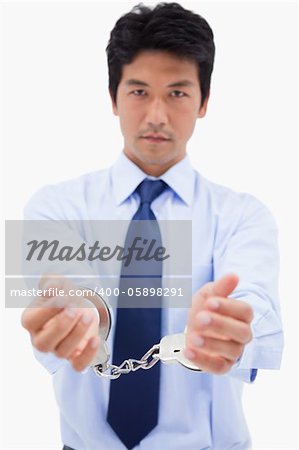 Portrait of a businessman with handcuffs against a white background