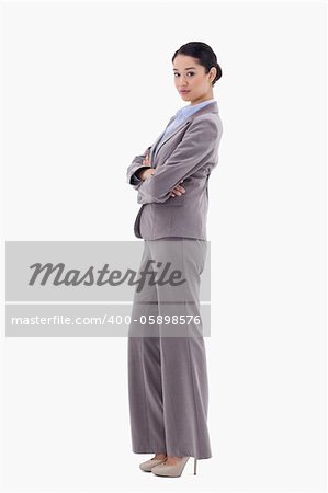 Portrait of a brunette businesswoman posing with the arms crossed against a white background