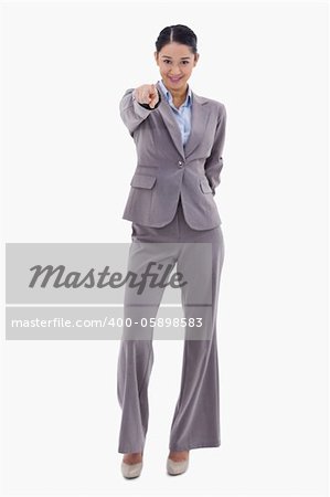 Portrait of a happy businesswoman pointing at the viewer against a white background