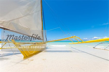traditional paraw sailing boats on white beach on boracay island, Philippines