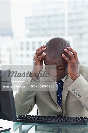 Portrait of a tired office worker using a computer in his office