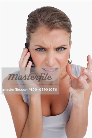 Portrait of an angry woman making a phone call against a white background