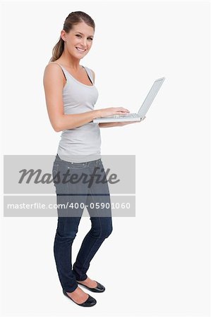 Portrait of a smiling woman using a laptop against a white background