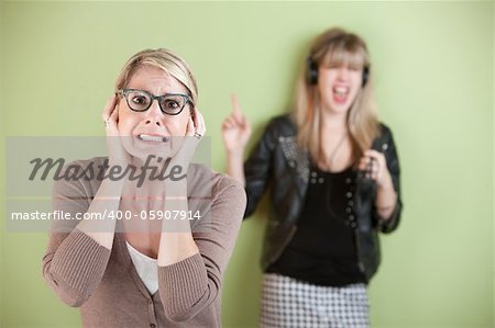 Woman with ears covered in front of loud teen