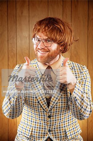 Excited 60s Game Show Host Giving 2 Thumbs Up audience. Wearing a patterned sports coat and a very ugly retro brown tie. The game show host is wearing a red toupee and a pair of thin rimmed glasses.