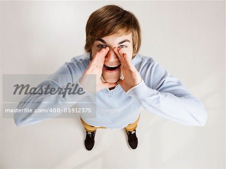 Portrait of a handsome young man looking up and shouting