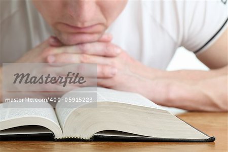 Man praying with the Bible. Focus on the Bible