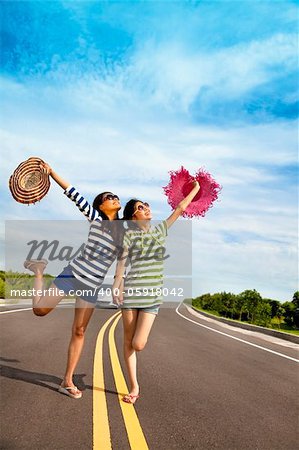 two girls having fun on the road trip at summertime