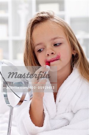 Little girl trying mom's lipstick - learning to be a modern woman