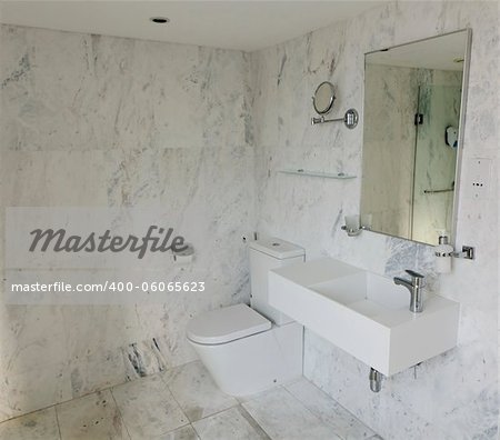 Modern, contemporary bathroom with mirror, makeup mirror, toilet and hand wash basin with light marble finish