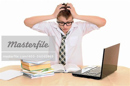 teenager student sits behind a desk isolated on white background