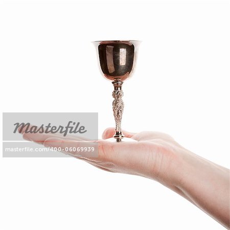 Female hand holding silver goblet isolated on white background