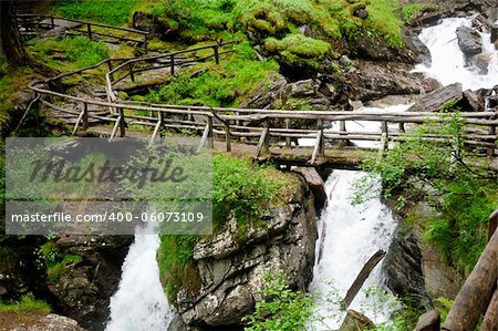 A wooden bridge over the so called Saent waterfalls, formed by the river Rabbies, in the Italian Dolomites