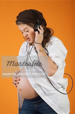 Pregnant woman with headphones singing to her baby