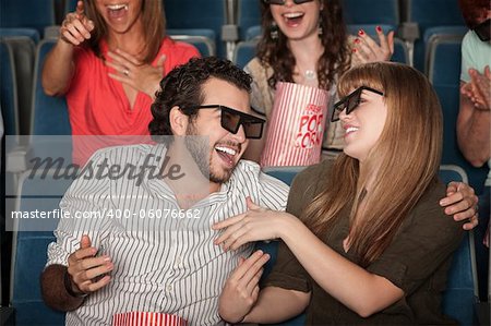 Couple with 3D glasses in theater laughing together