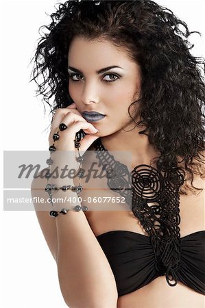 portrait of young and very beautiful brunette with curly hair wearing a fashion black swimsuit and jewellery