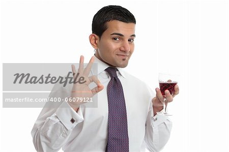 A man holding a glass of wine makes a hand sign to show approval, or excellence.  White background.