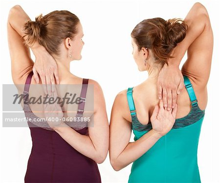 Two fit women stretching their arms over white background