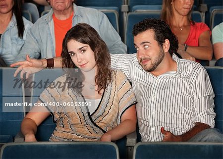 Man flirts with young woman in theater