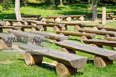 outdoor wood benches on green lawn in sunny day