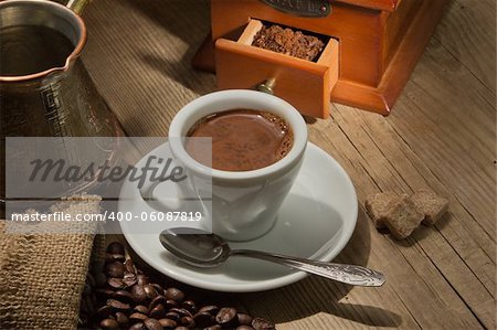 Wooden grinder with coffee beans on the tree with a bag