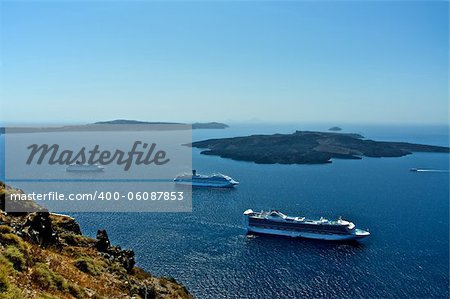 In the caldera of an ancient volcano a lot of cruise ships and boats. Thousands of tourists come here for a tour.