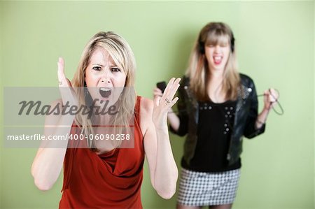 Annoyed woman in front with noisy girl with headphones