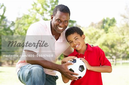 Father And Son In Park With Football