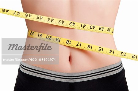 Woman measuring her waist with a yellow measuring tape