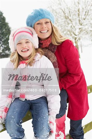 Mother And Daughter Standing Outside In Snowy Landscape