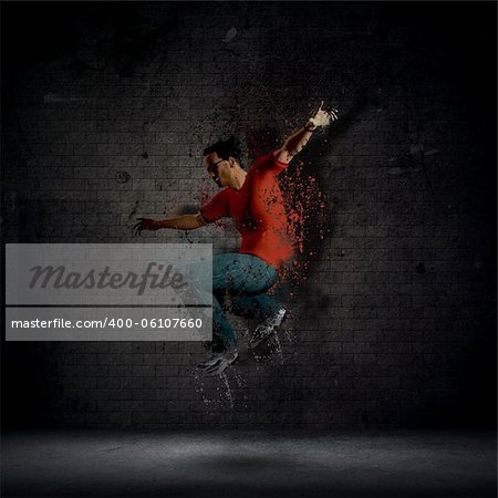 Abstract grunge man dancing against a dark brick wall