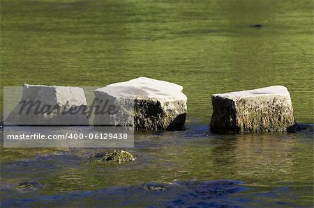 3 stepping stones in river, dovedale, peak district, uk