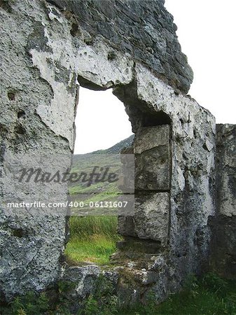 ruin of a thatched building at the base of the great irish hills