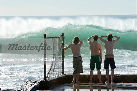 Three young boys checking out the surf.