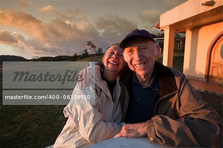 Loving elderly couple smiling at table in mountains