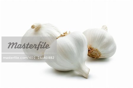 Three cloves of garlic arranged on a white background close-up.