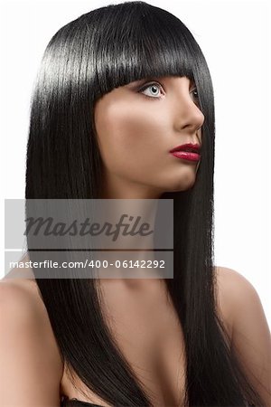 pretty girl with long, dark smooth hair and fringe, she is turned of three quarters at left and her half face is hidden by the hair