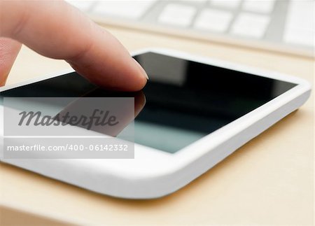 Closeup of Man's Hand Touching Screen of White Modern Smartphone - Shallow Depth of Field