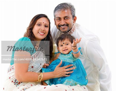 Traditional Indian family with one child sitting on white background