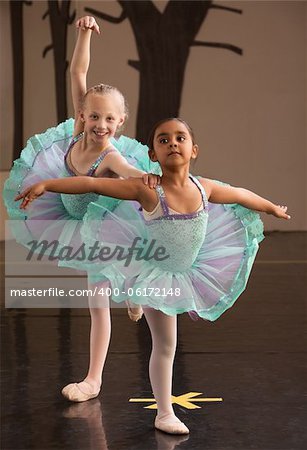 Two ballet students in fancy dresses posing together