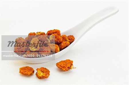 dried goldenberries (physalis peruviana,) , superfruit from Peru rich in antioxidnats, vitamin A, bioflavonoids, and dietary fiber, a ceramic tablespoon