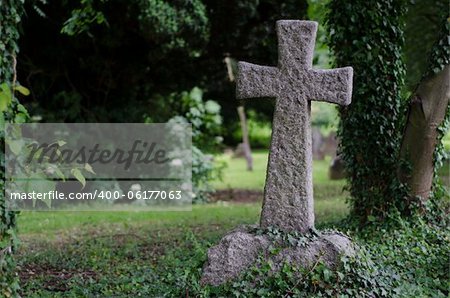 A stone cross on an angle in a graveyard.