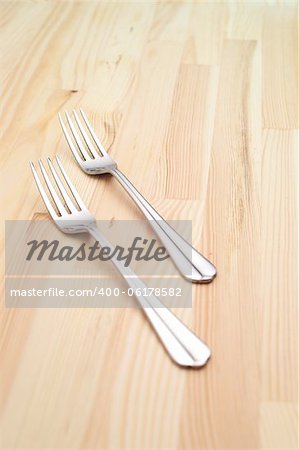 two fork on a kitchen pinewood table closeup