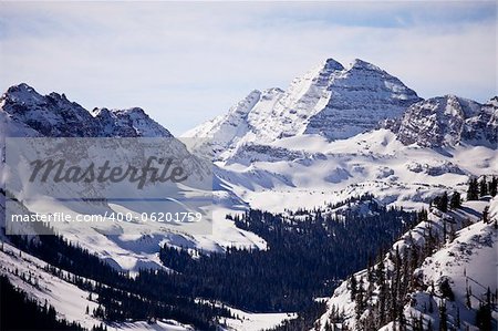 A winter view of the Maroon Bells mountain peaks in Colorado from a nearby mountain.