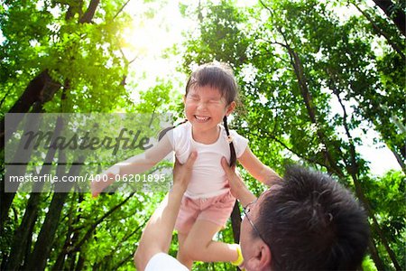 happy little girl with father in the green forest at morning