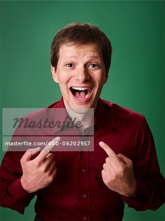 mid adult business man pointing at himself against green background and looking at camera