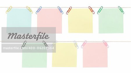 Seven blank sticky notes held on strings with colorful paperclips isolated on white.