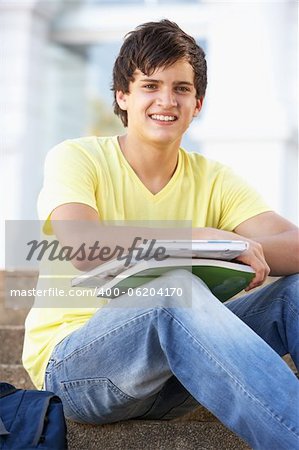 Male Teenage Student Sitting Outside On College Steps